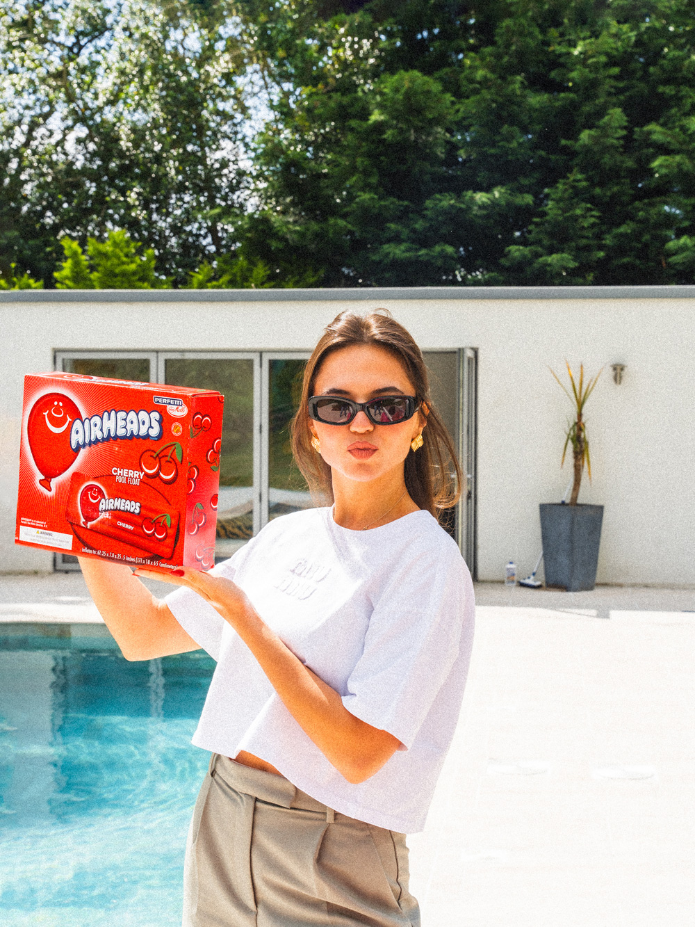 On set behind the scenes, colleague posing with an Airheads product by a pool